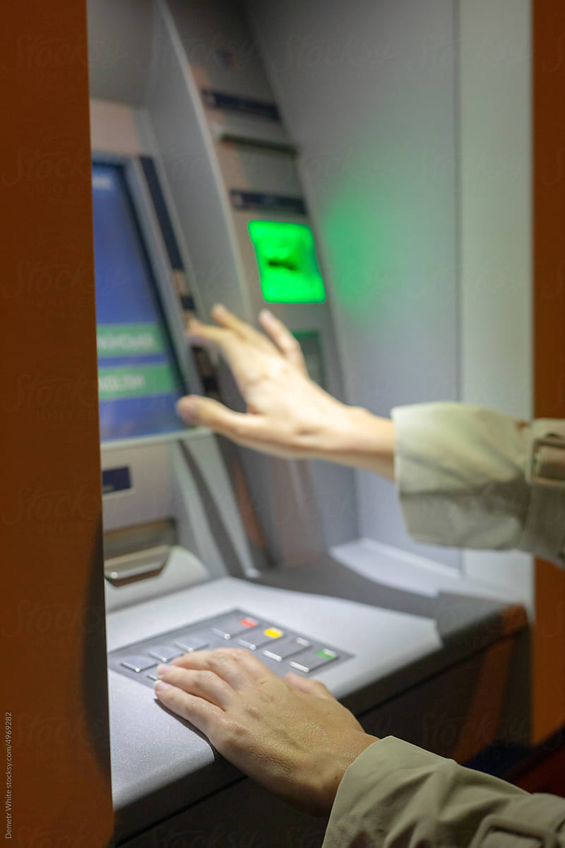 woman enters data on the panel of an ATM