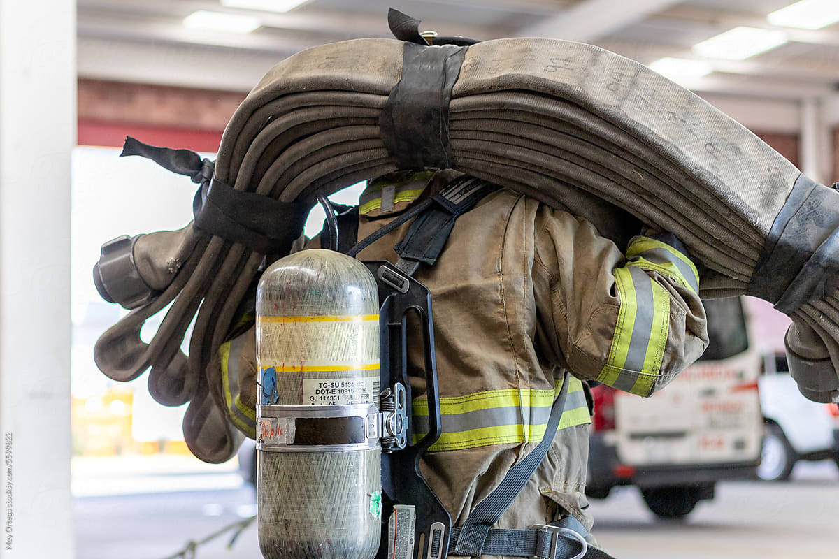A Firefighter Carrying A Hose On His Shoulders While Exercising