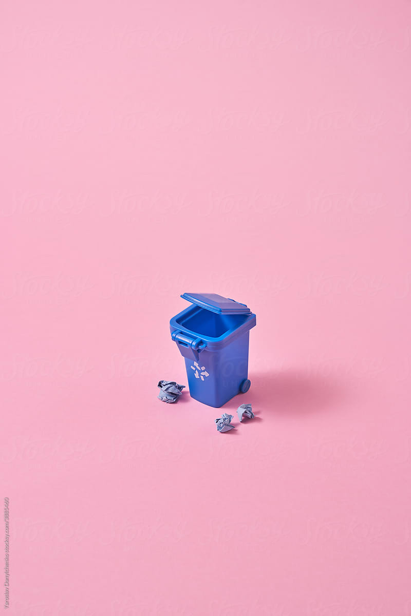 Blue garbage container and crumpled paper