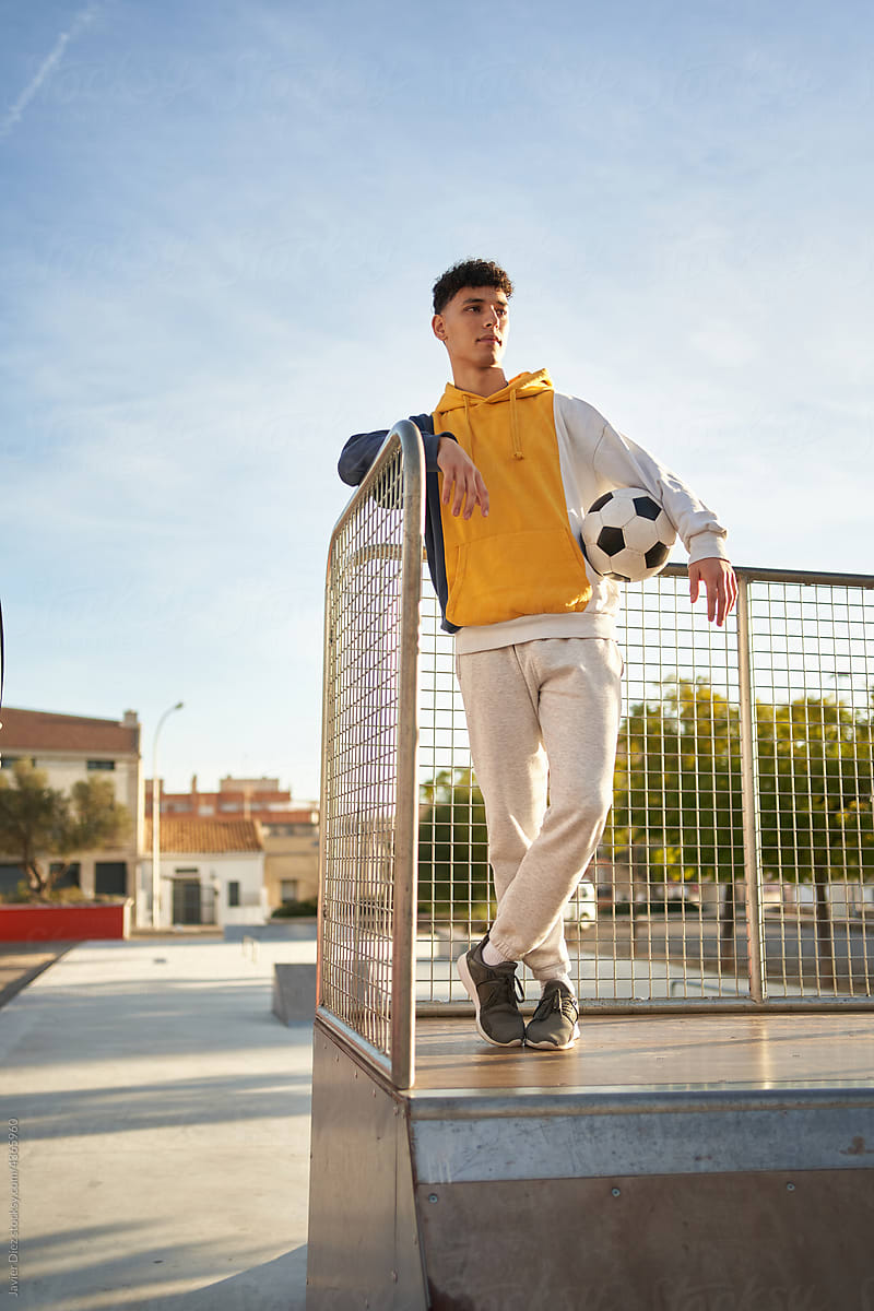 Man with soccer ball standing in skate park