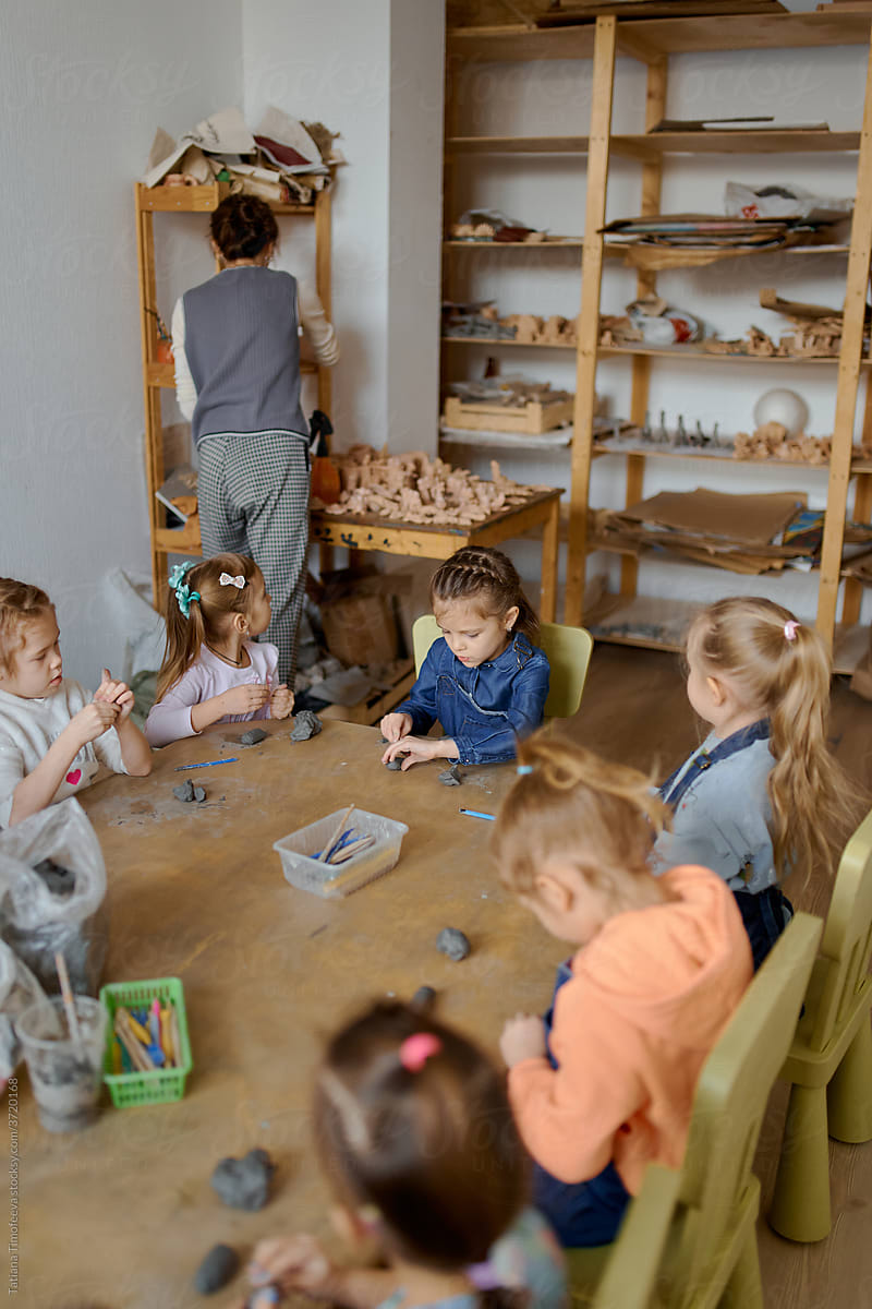 preschool teacher with children in ceramics lesson at  art school