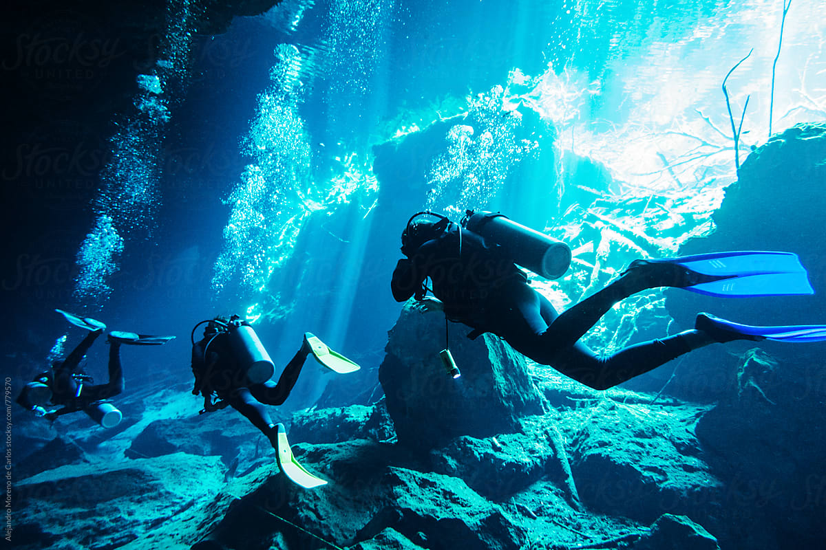 Scuba divers diving in an underwater cave in a cenote in Yucatán, Mexico