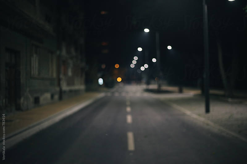 Empty street during the night. Blurry. by VeaVea - Stocksy United