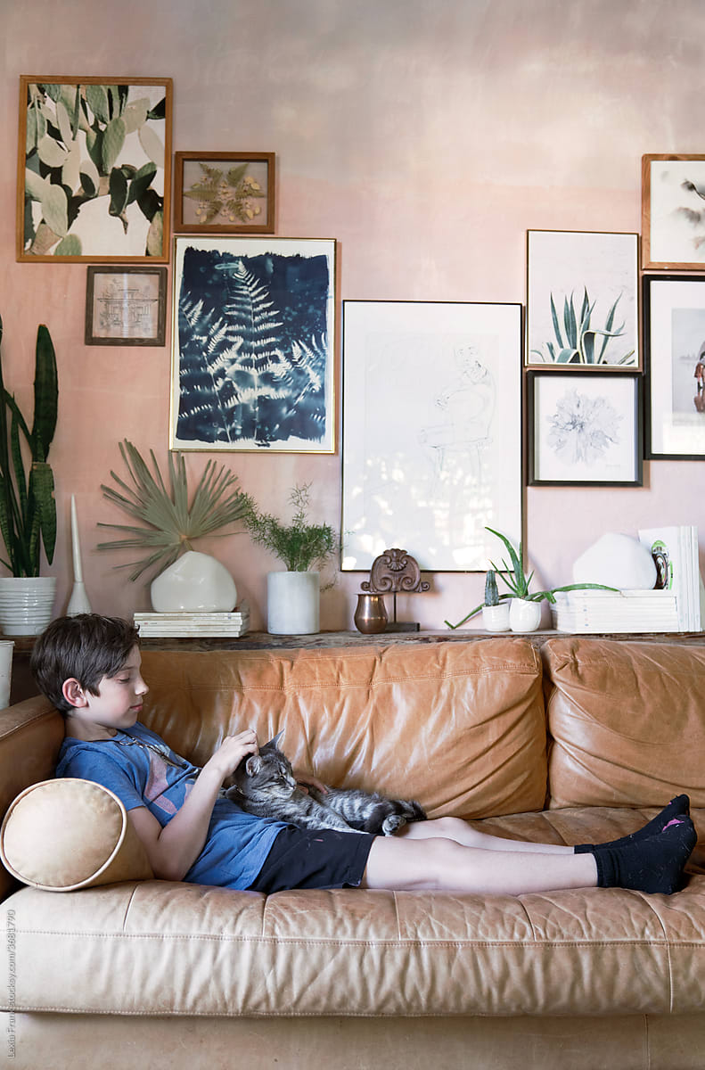 boy relaxes on couch in modern bohemian home