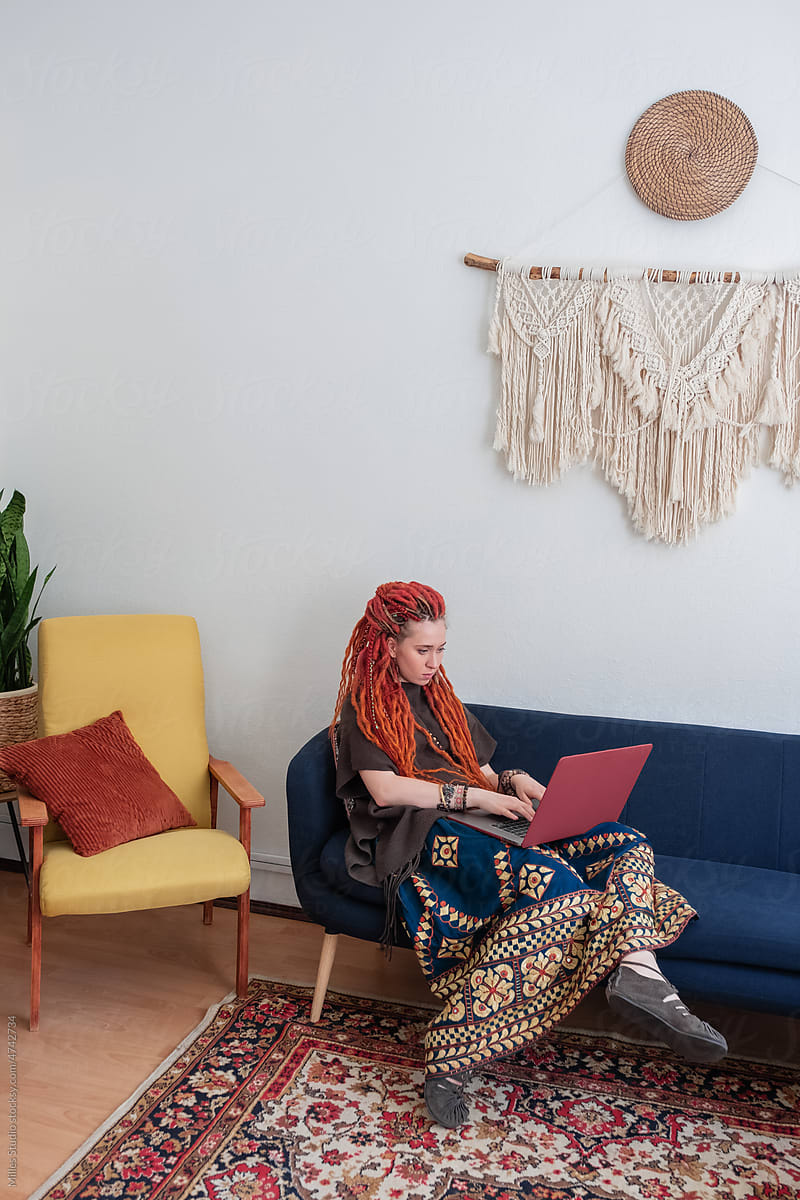 Female freelancer using laptop on sofa