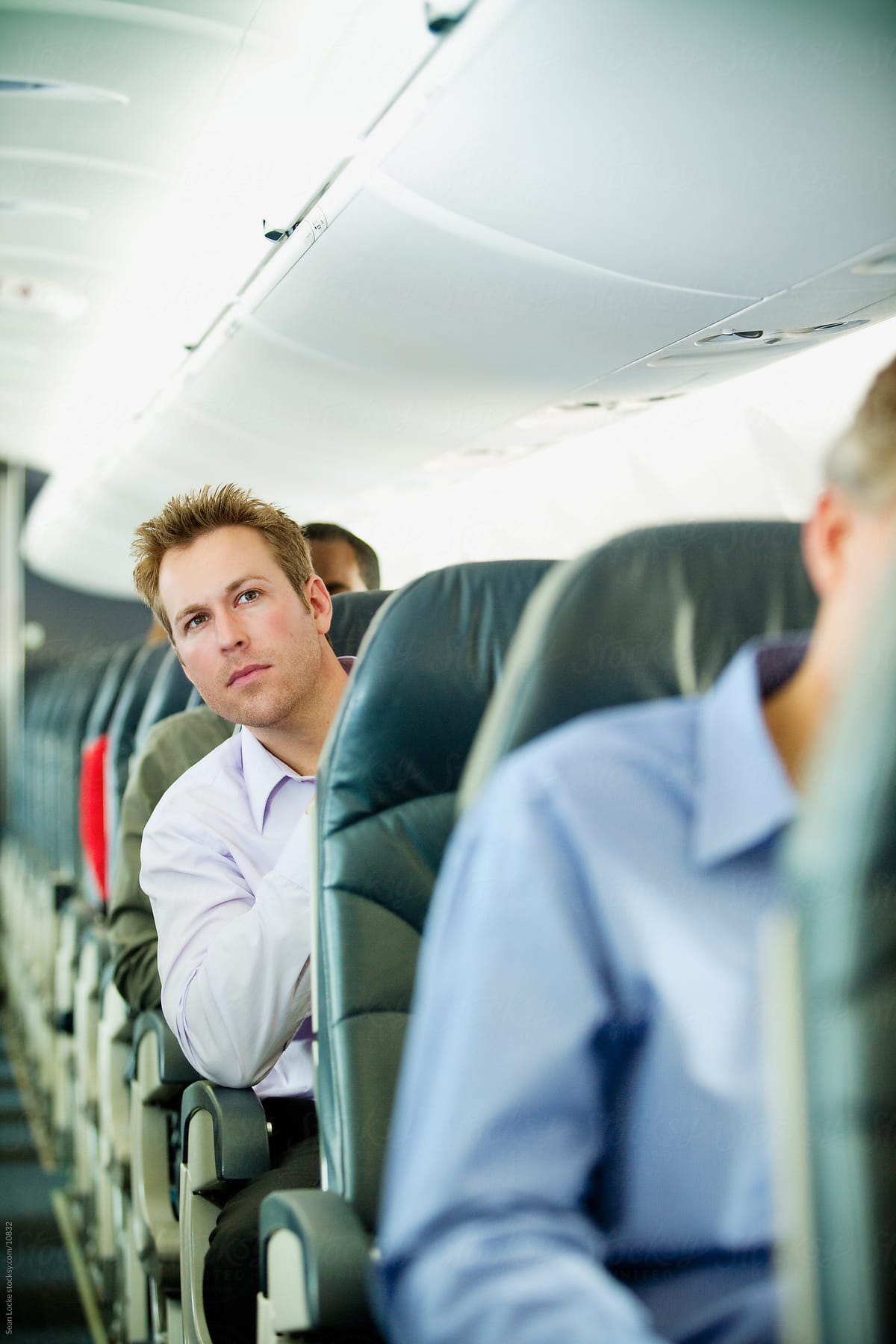 Airplane: Concerned Passenger Looks Down Aisle