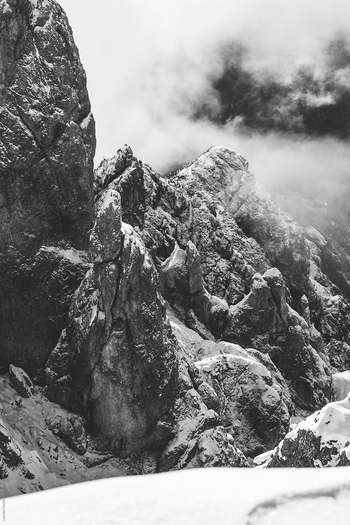steep snowcovered mountain ridge covered in fog - black and whit