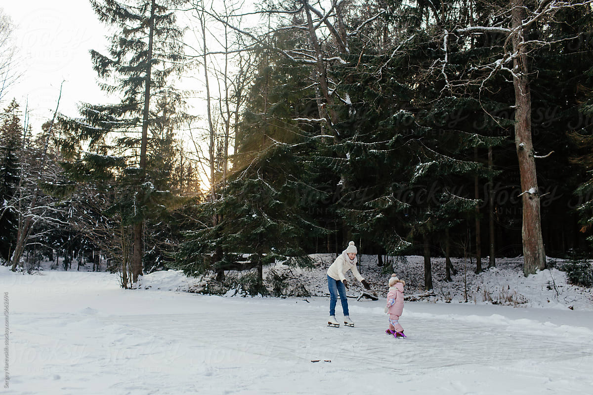 Little child skating in forest with mother