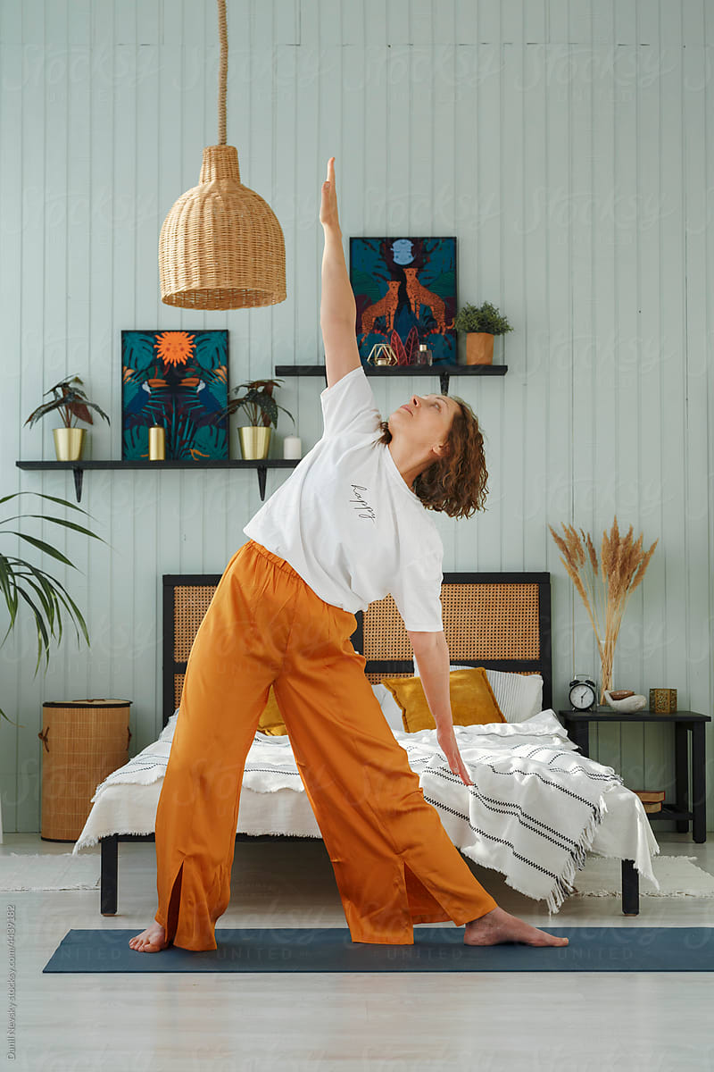 Woman practicing Reverse Triangle asana on mat in flat