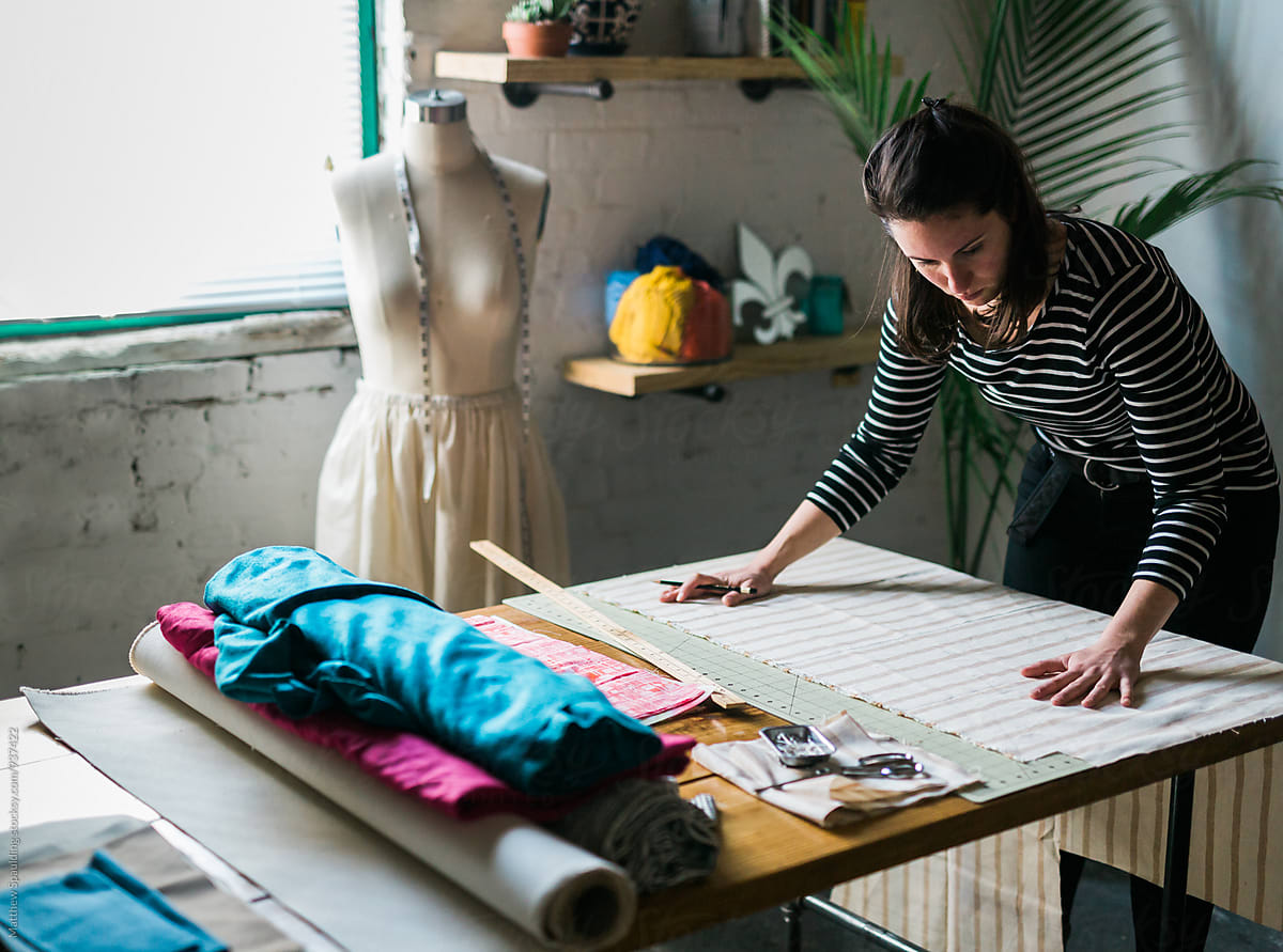 Designer measuring fabric for clothing pattern
