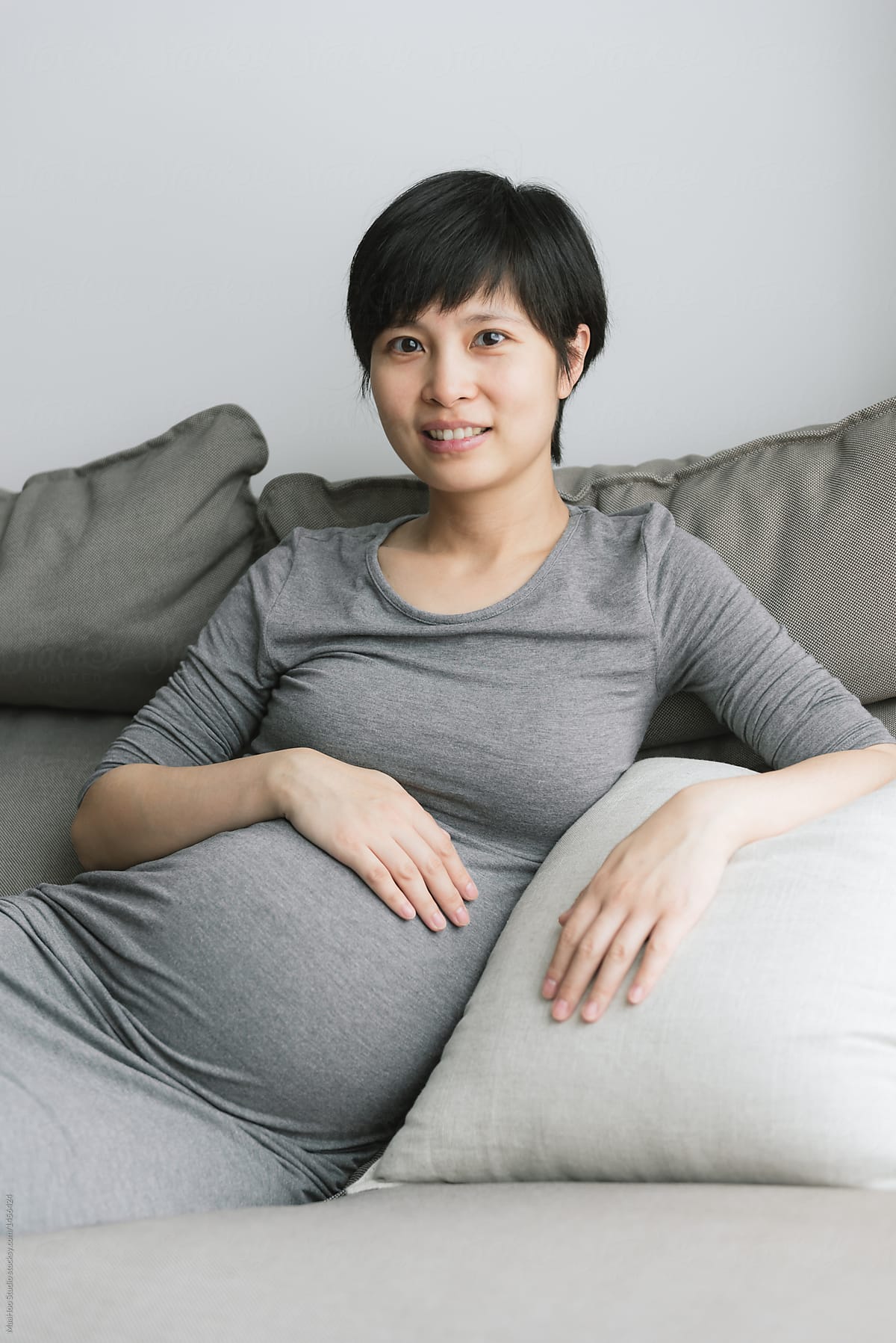 Young Pregnant Woman Holding Stomach By Stocksy Contributor Maahoo