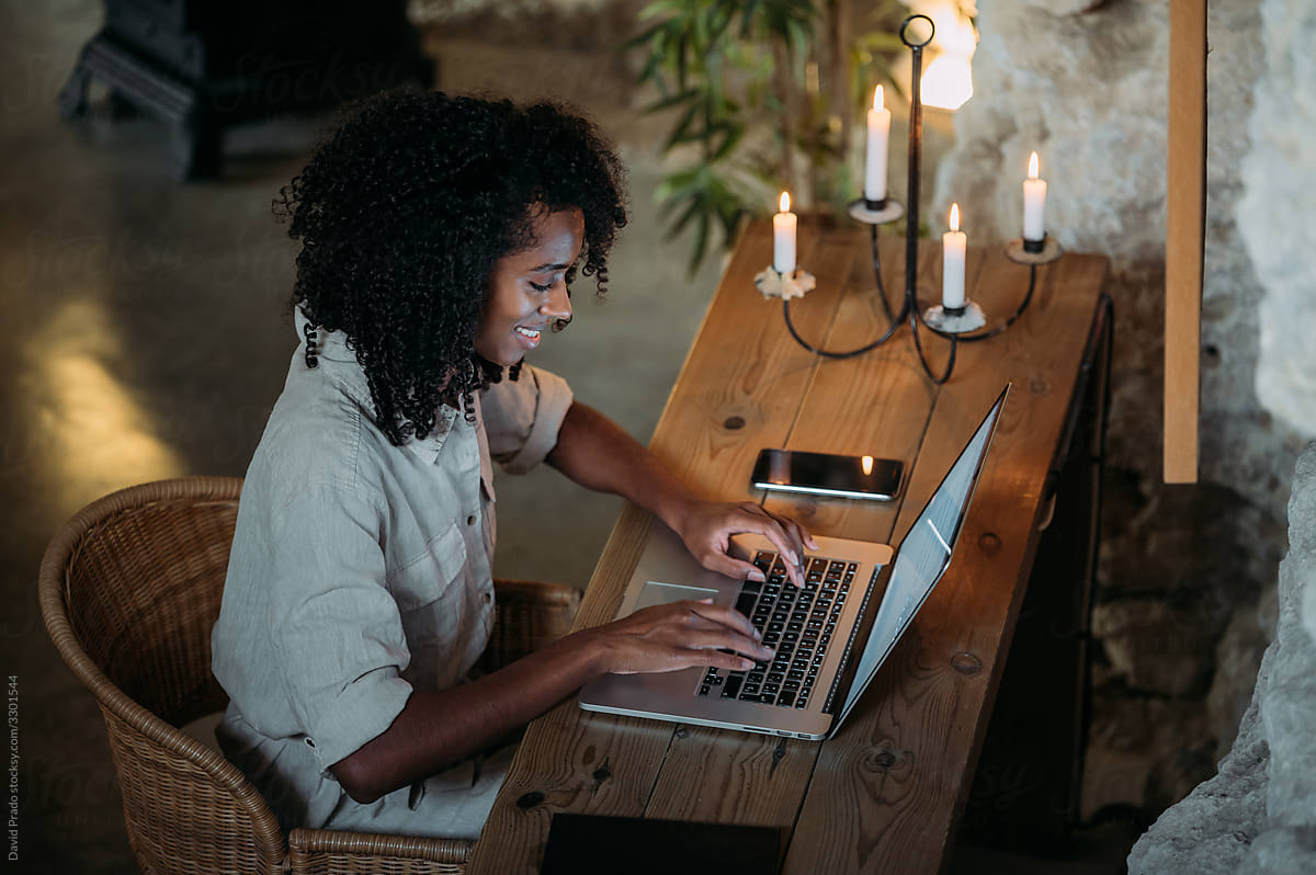 Black woman using laptop in evening