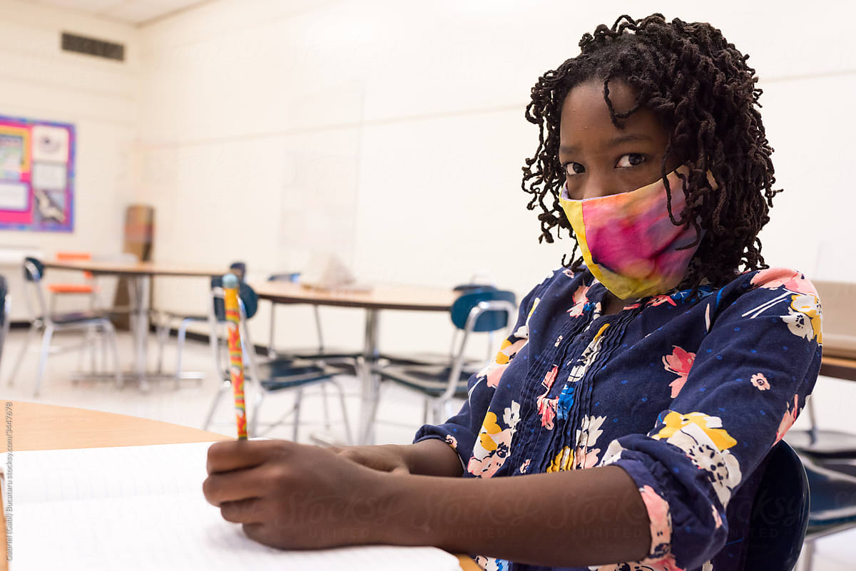 Black girl with mask in a classroom