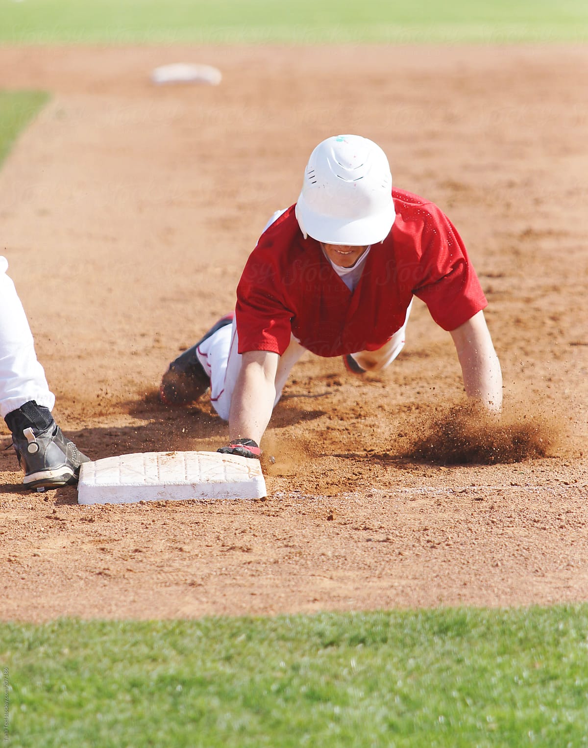 A baseball player sliding back to first base
