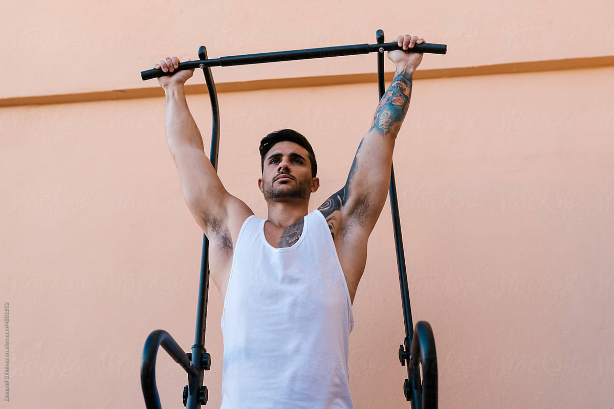 Tattooed athlete exercising on the barbell