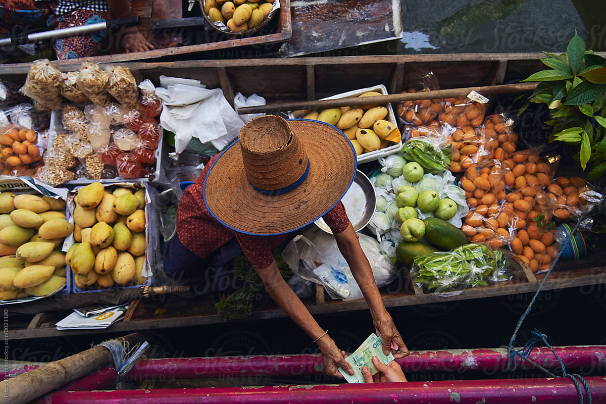 Unrecognizable tourist buying fruits from floating market