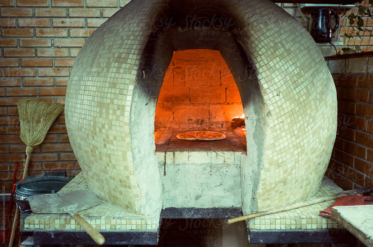 Wood oven and a hand made pizza cooking inside it
