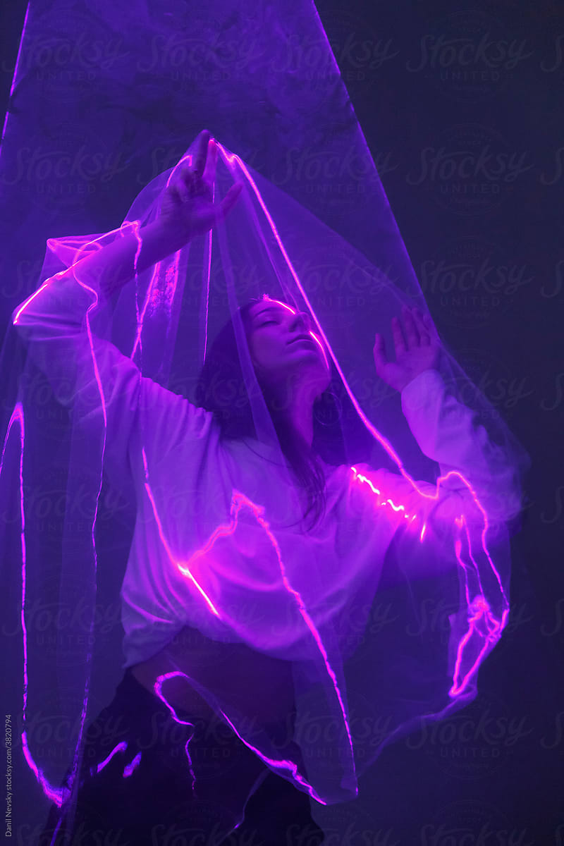 Sensual woman with veil in neon illumination