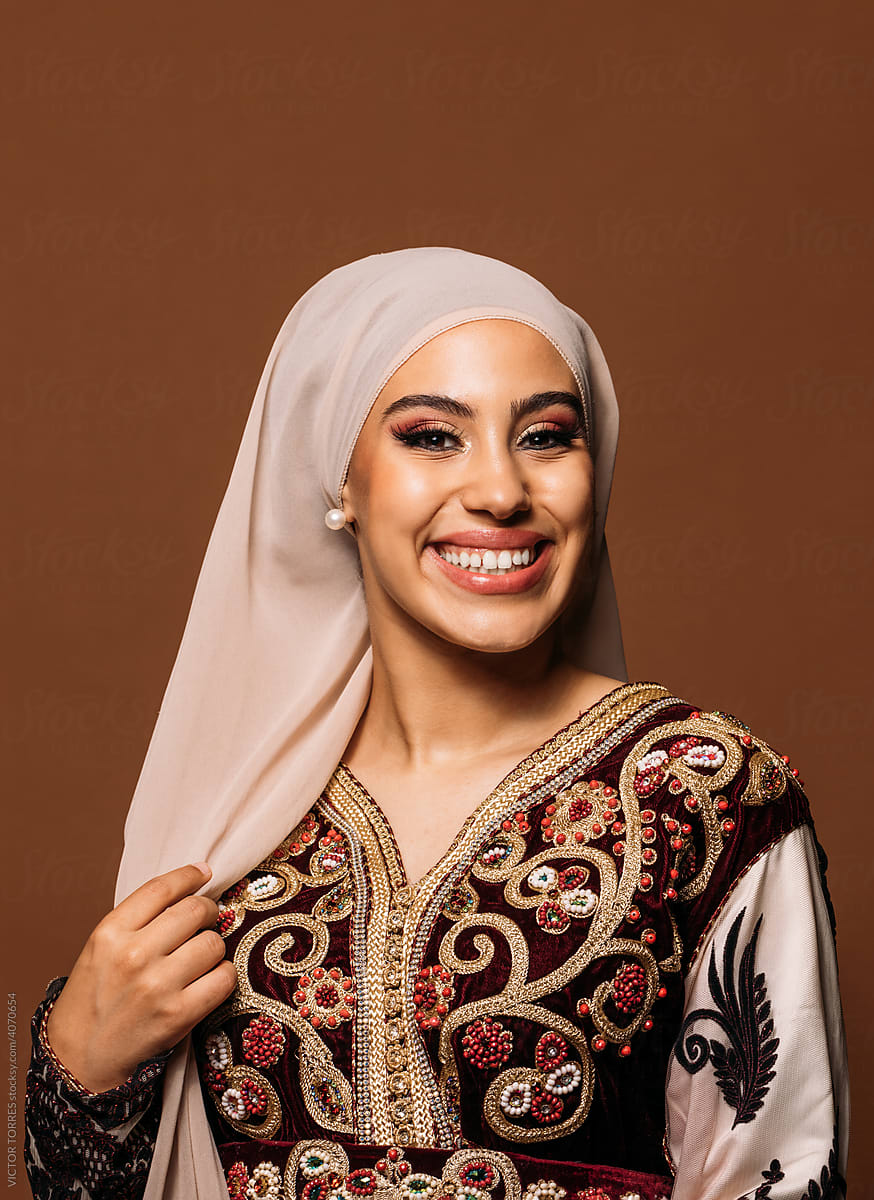 Laughing muslim woman in hijab standing in studio