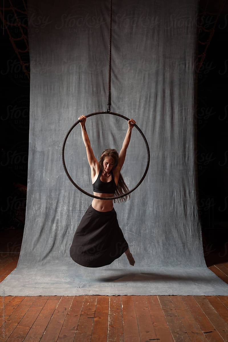 Aerial artist in a dynami pose on a Lyra or Aerial hoop