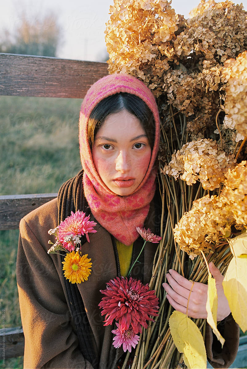 girl with freckles holds autumn flowers