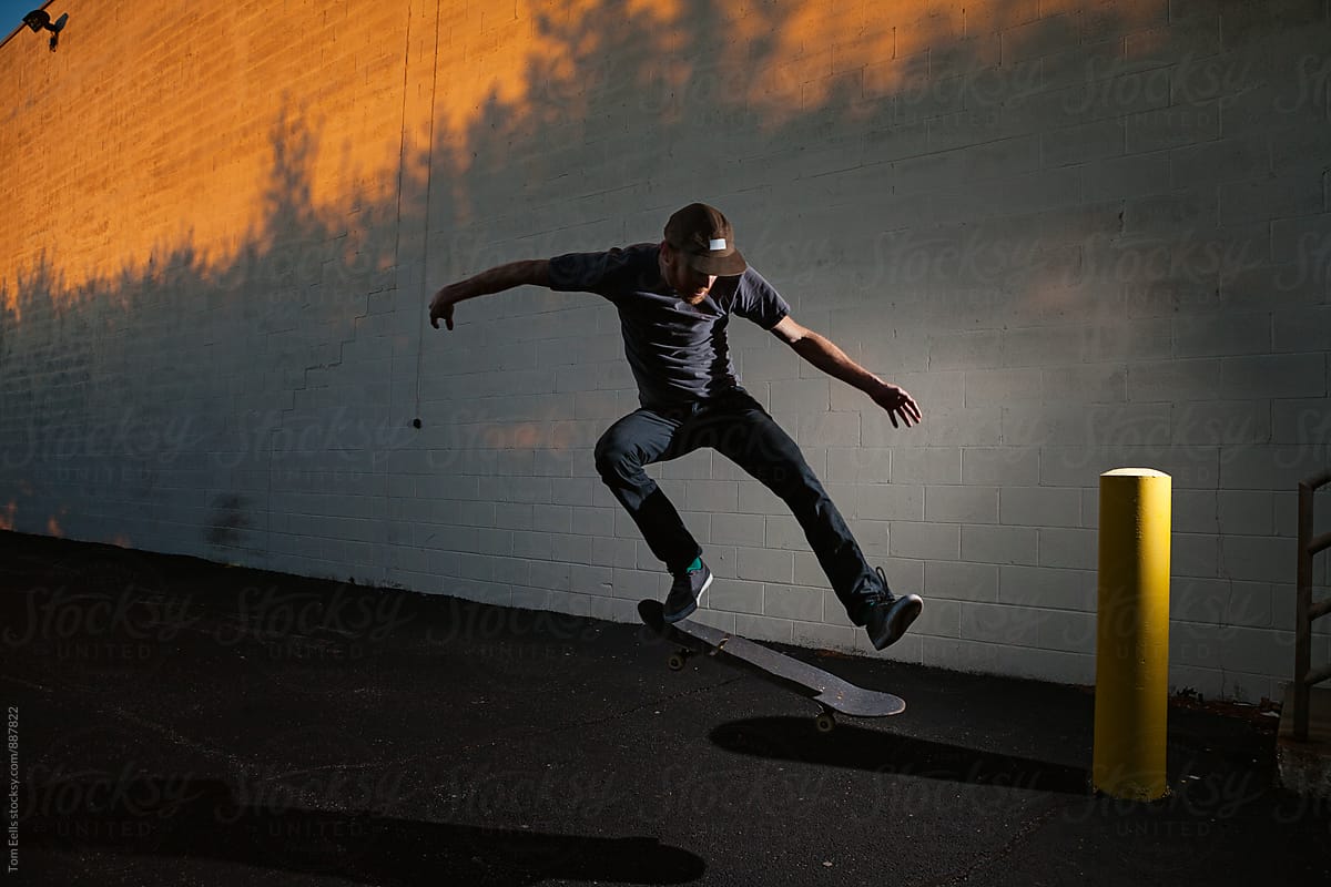Skateboarder skating in the city at sunset