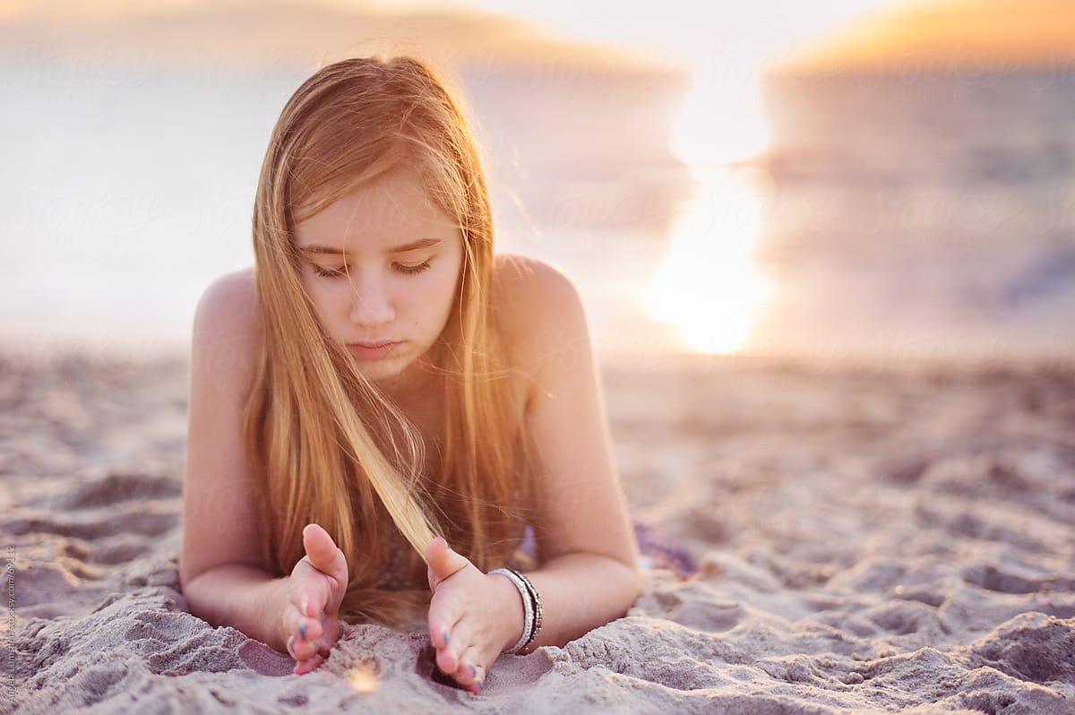 Girl Playing With Sand At The Beach At Sunset By Stocksy Contributor Angela Lumsden Stocksy
