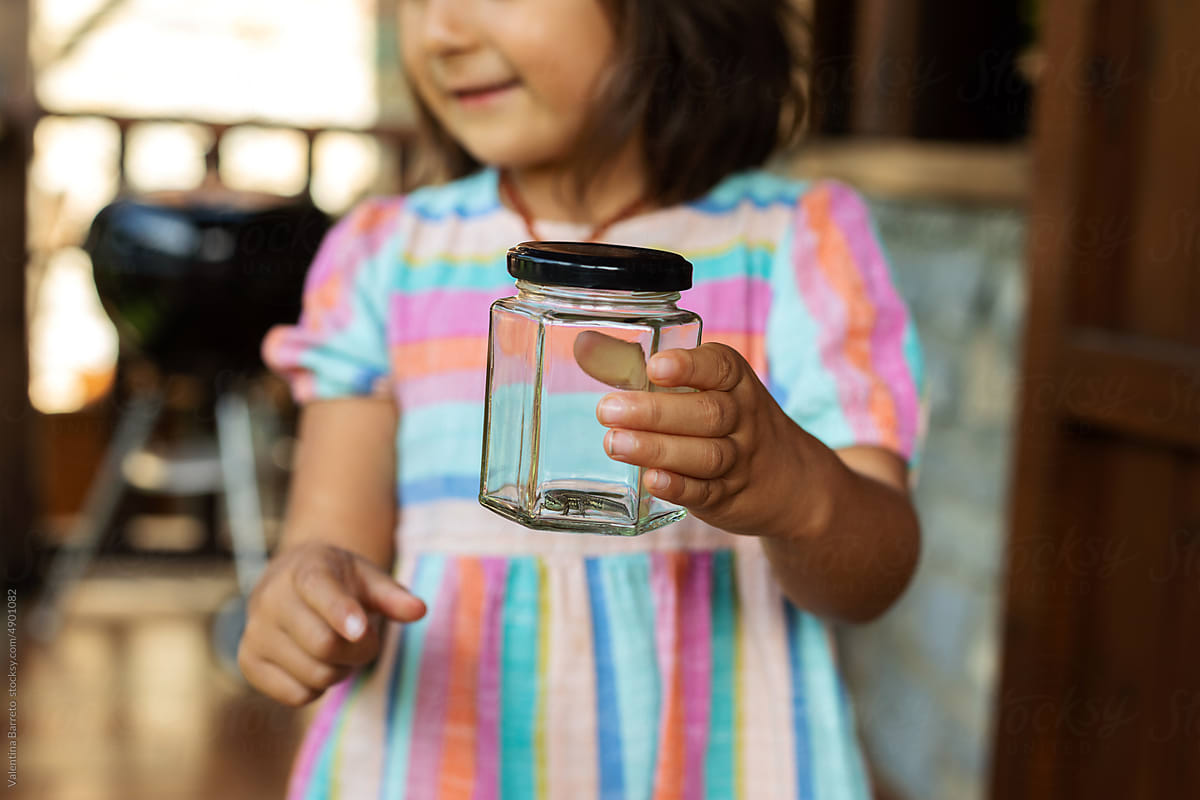 young girl holding mason jar