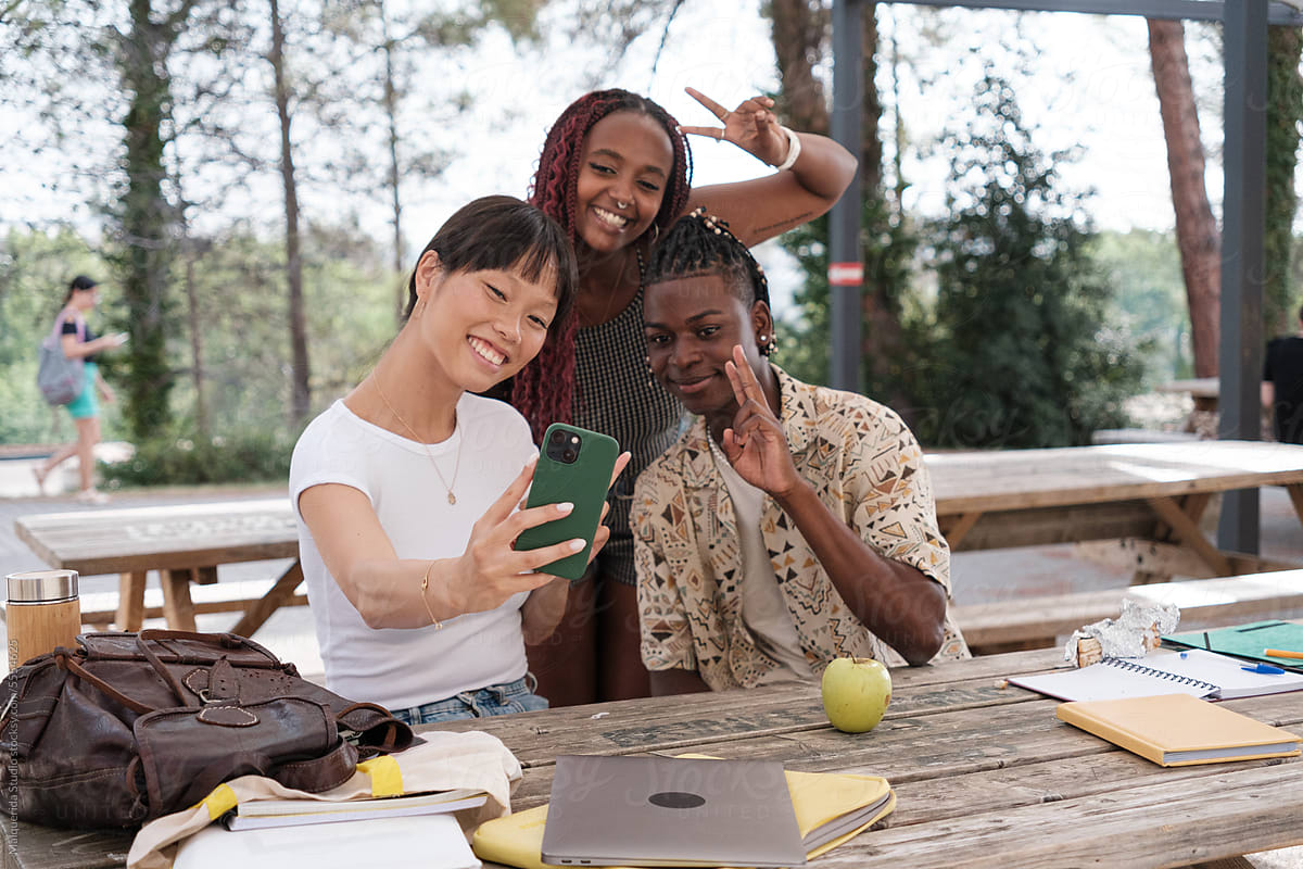Students taking selfie with smartphone outdoors
