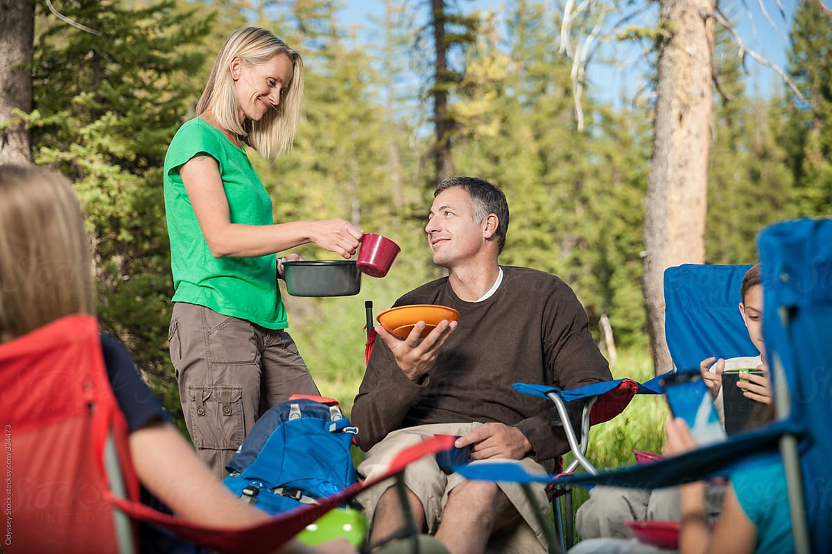 Mother Serving Dinner to Family on Campout