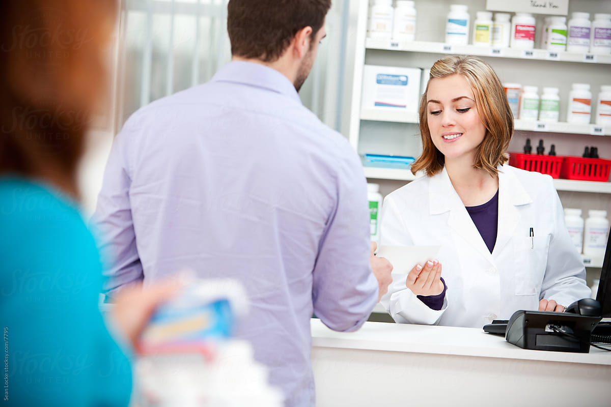 Pharmacy: Man Hands Paper Prescription to Pharmacist