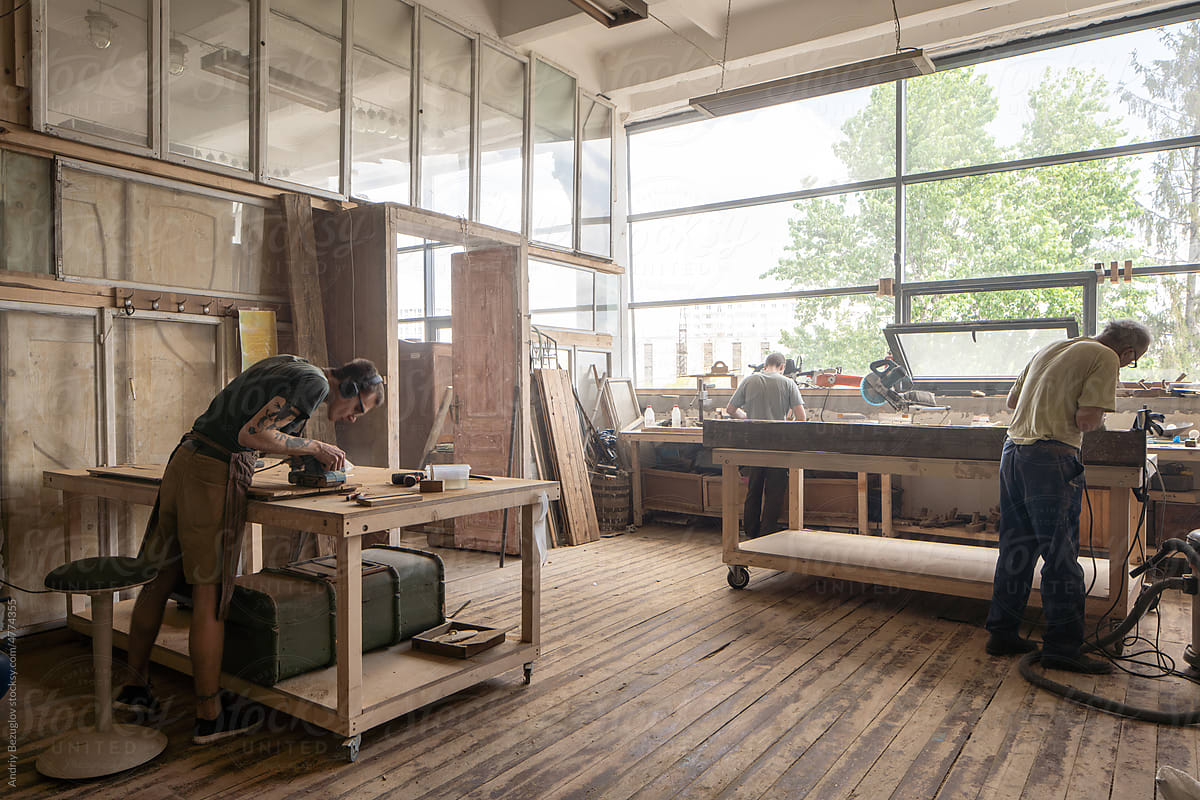 Men sanding at the workshop and repairing old vintage furniture