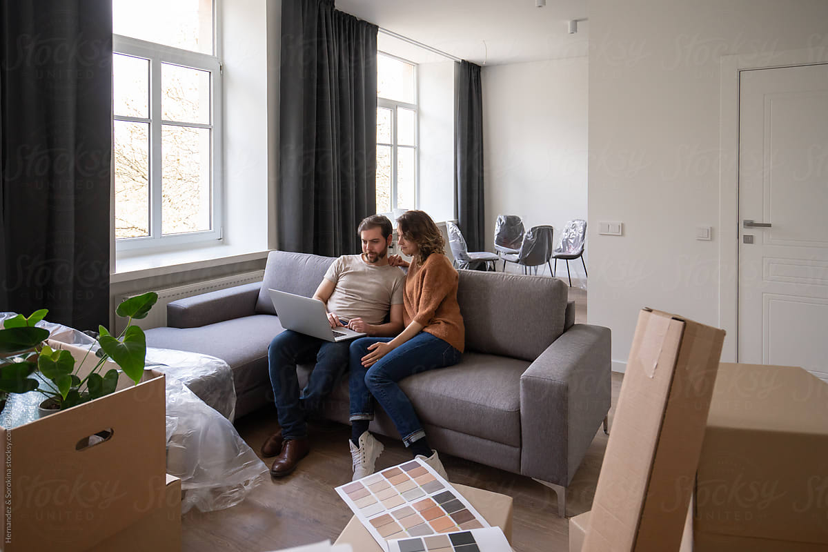 Couple Using Laptop At Their New Apartment