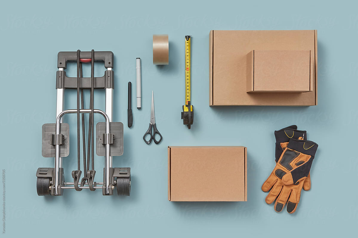 Cardboard boxes and packaging tools on blue background.