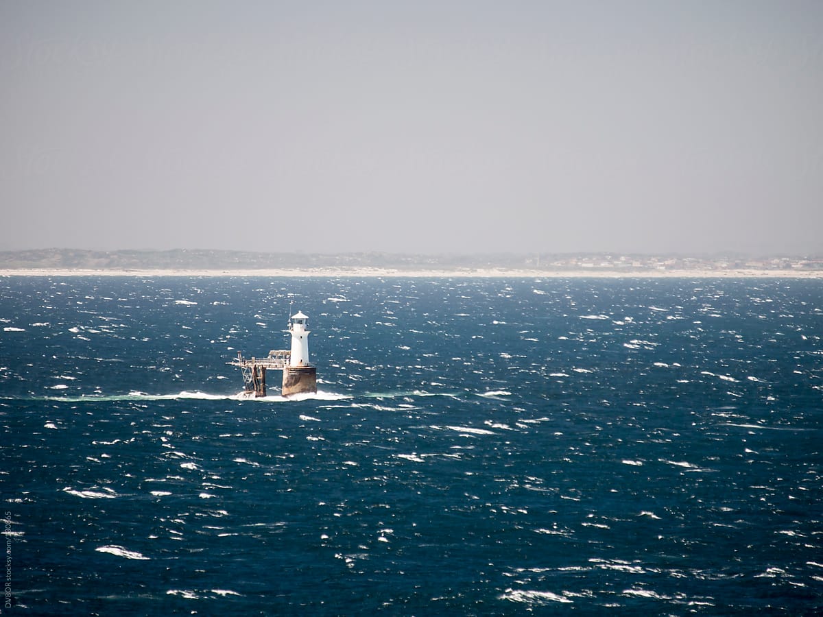 Lighthouse on windy seas with waves