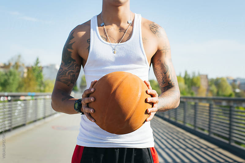 Close Up of Mixed Race Man Holding Basketball on Sunny Summer Day
