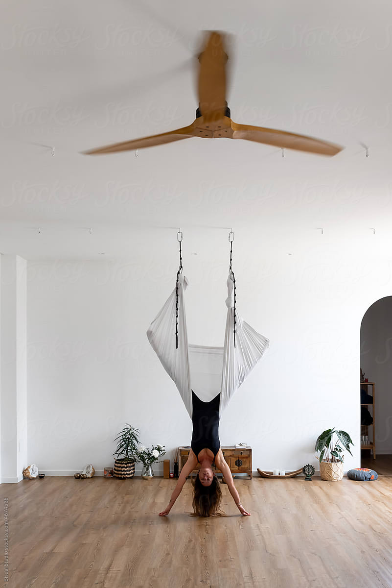 Young Woman Upside Down Doing Aerial Yoga