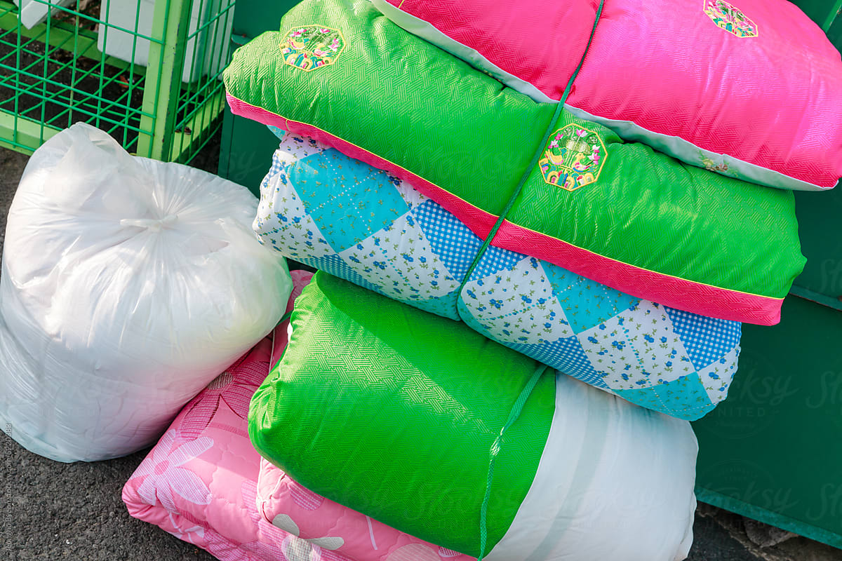 Bundle of colorful quilts discarded at a recycling center.