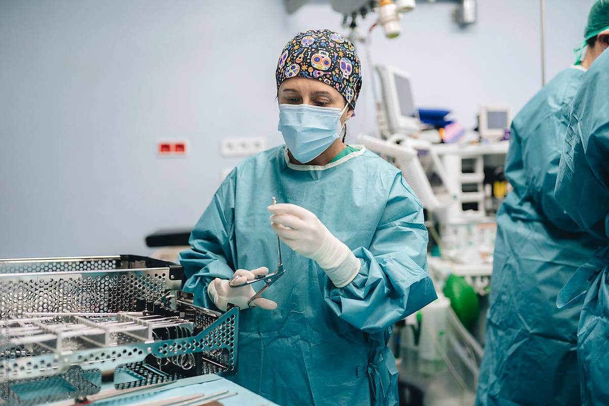 Nurse with forceps in operating room