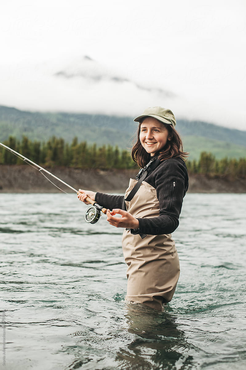 Fisherwoman Smiling While Holding A Fishing Pole In The Kenai River by  Stocksy Contributor Sophia Juliette - Stocksy