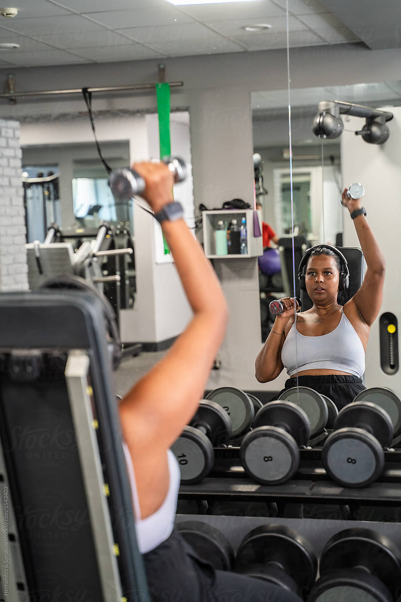 Woman Working Out With Dumbbells In The Gym