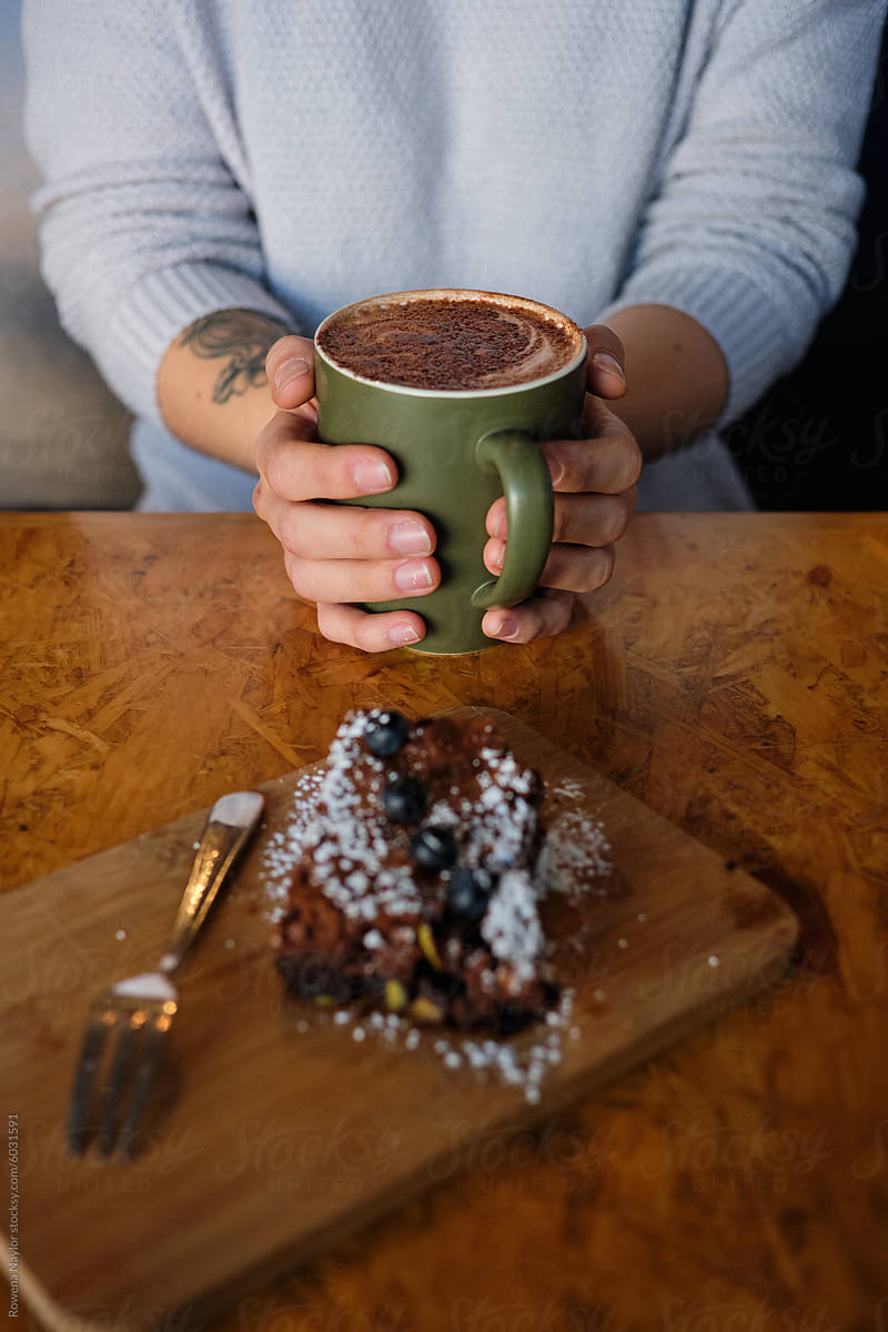Woman\'s hand wrapped around warm mug of hot chocolate