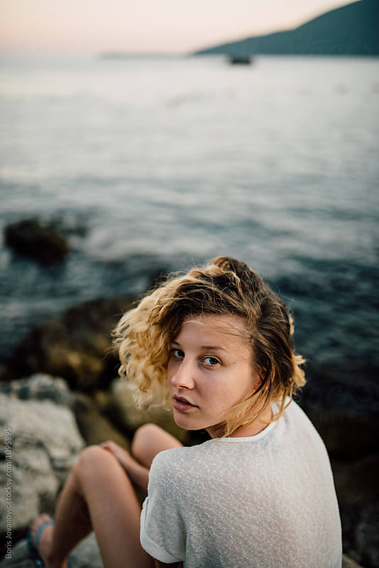 Young woman sitting near the sea