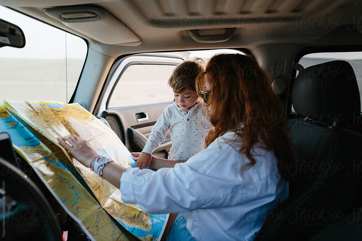 Mother and her son with a map in a car