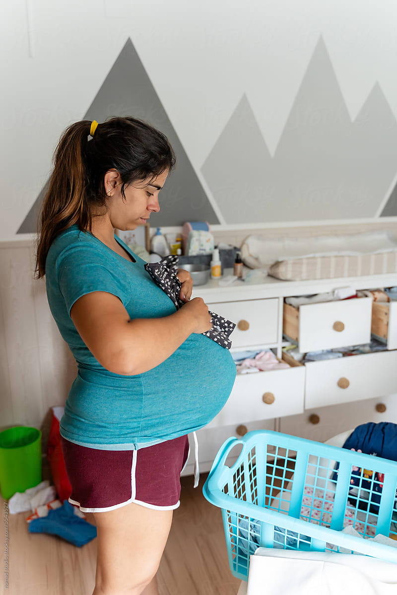 pregnant woman sorting clothes