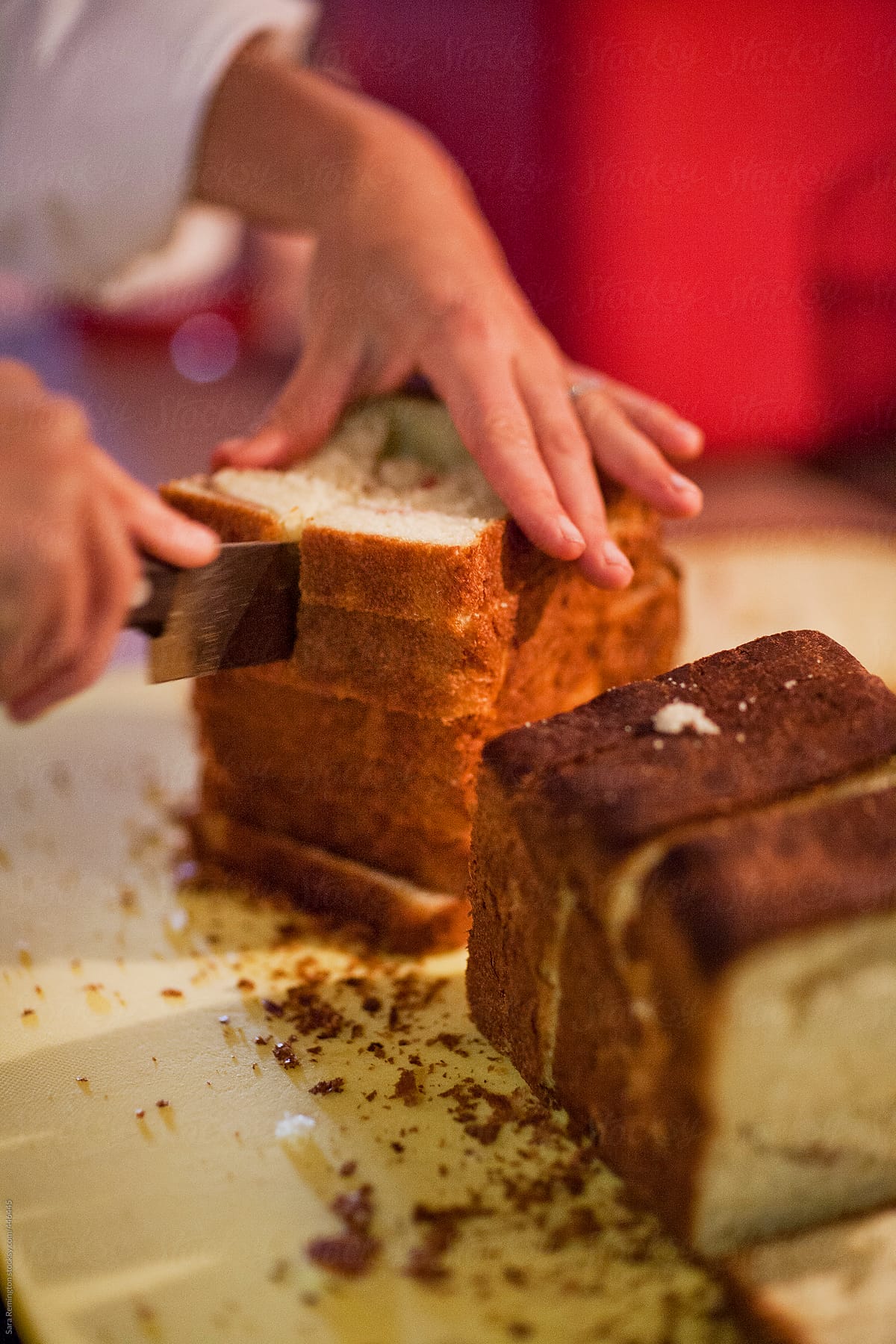Chef Cutting Bread In Kitchen