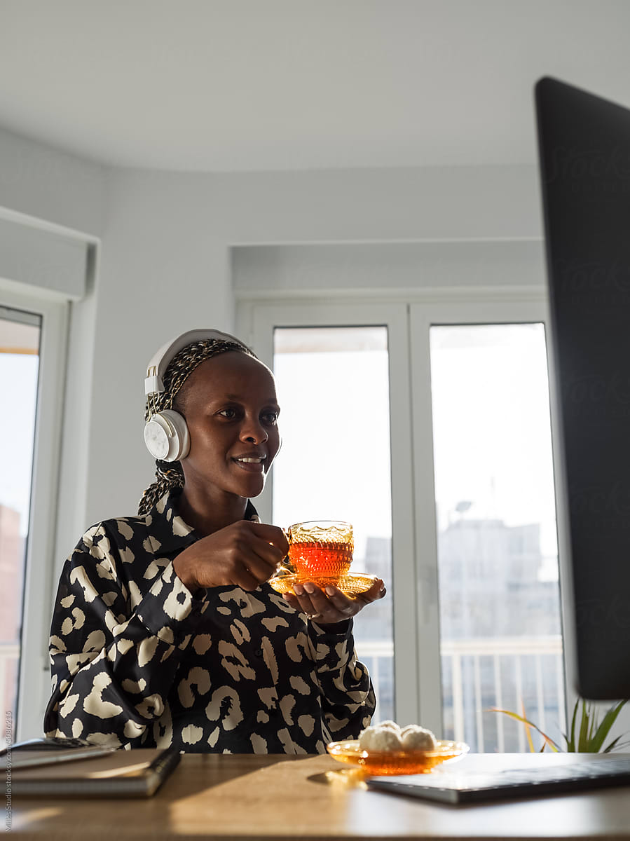 Smiling black woman enjoying delicious hot tea