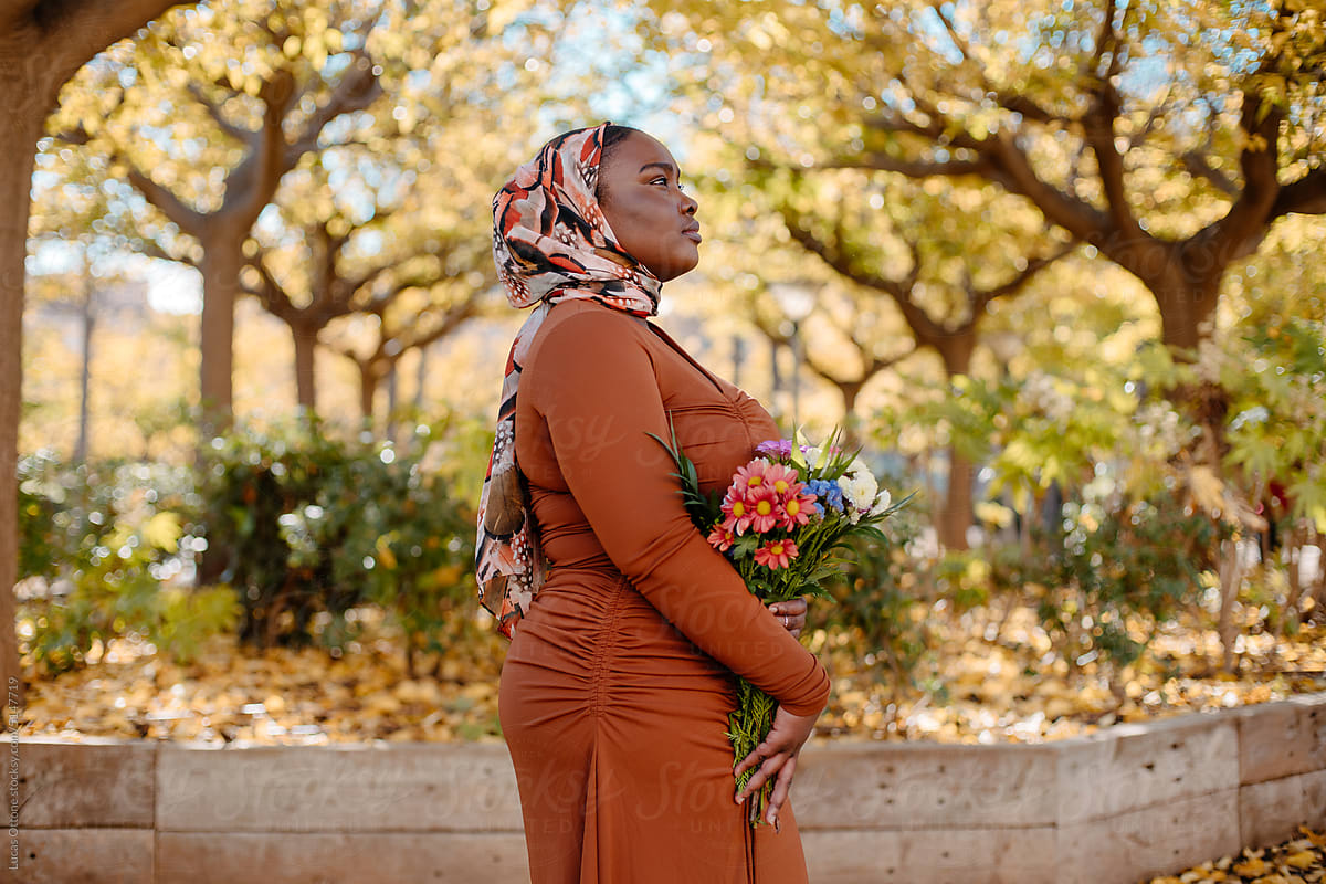 Black muslim woman holding flowers