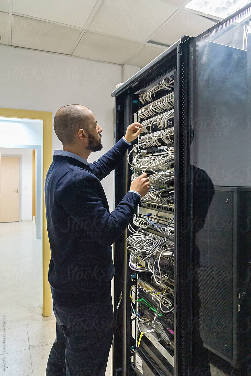 Computer technician professional connecting cables in a rack