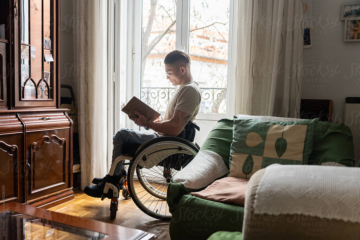 Young Man With A Disability Reading A Book